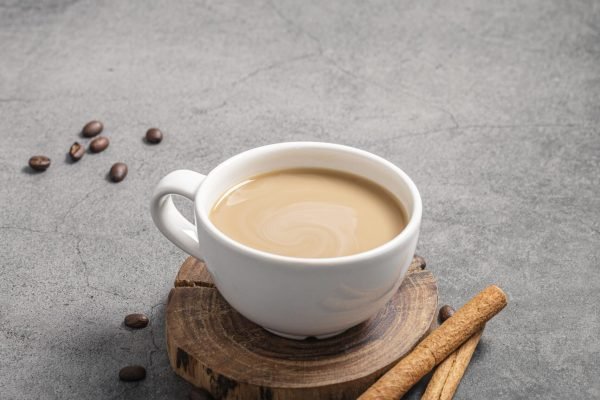 high-angle-coffee-cup-with-cinnamon-sticks-copy-space